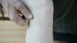 man scratching back of knee
