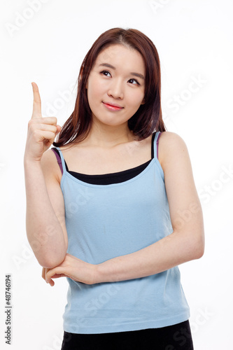 Photo: Smiling young woman pointing upwards Smiling young woman pointing upwards