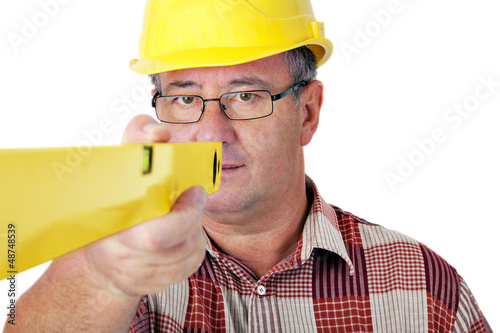 Photo: Construction worker looks at the spirit level Construction worker looks at the spirit level