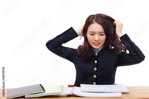 Photo: Young Asian student having trouble on desk. Young Asian student having trouble on desk.