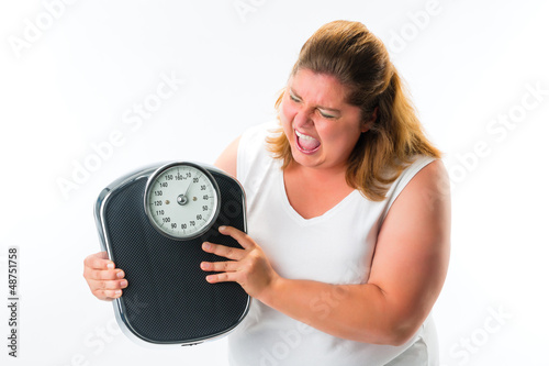 Photo: obese woman looking angry at scale obese woman looking angry at scale