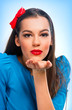 Portrait of a beautiful woman in blue sending kisses