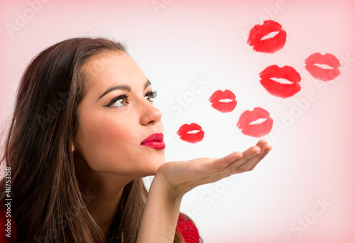 Photo: Portrait of a beautiful woman blowing red kisses Portrait of a beautiful woman blowing red kisses