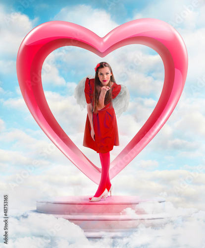 Photo: Beautiful angel woman sending love from the heart shaped gate Beautiful angel woman sending love from the heart shaped gate