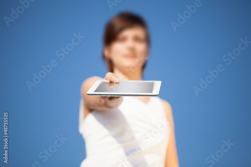 Photo: Young woman looking at modern tablet Young woman looking at modern tablet