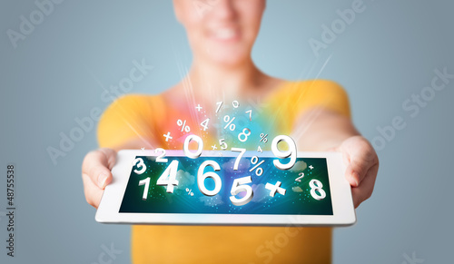 Photo: Young woman holding tablet with numbers Young woman holding tablet with numbers
