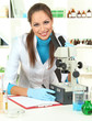 Young scientist looking into  microscope in  laboratory.