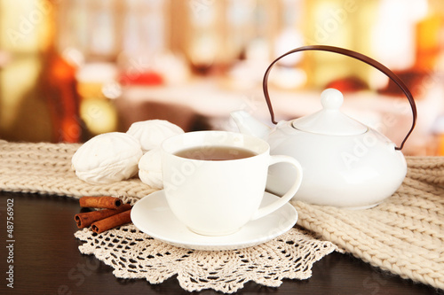 Photo: cup of tea with scarf on table in room cup of tea with scarf on table in room