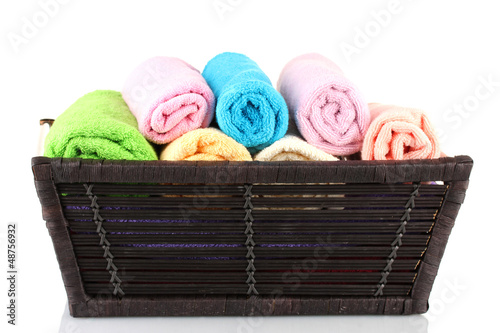 Photo: Colorful towels in basket isolated on white Colorful towels in basket isolated on white