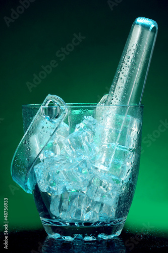 Photo: Glass ice bucket on dark green background Glass ice bucket on dark green background