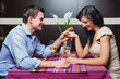 Young couple sitting in restaurant and flirting