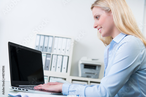 Photo: junge angestellte sitzt am notebook junge angestellte sitzt am notebook