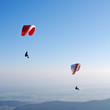 Zwei Paragleiter vor blauem Himmel