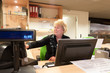 Senior volunteer female cashier at museum