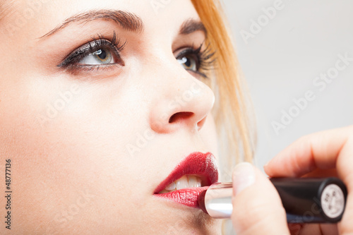 Photo: Woman applying lipstick Woman applying lipstick