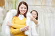 Foto: Female shop consultant helps girl chooses fur cape Female shop consultant helps girl chooses fur cape