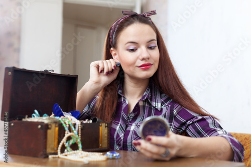 Photo: portrait of woman tries earrings portrait of woman tries earrings