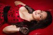 Photo: Pin-up girl lying on a red leather couch Pin-up girl lying on a red leather couch