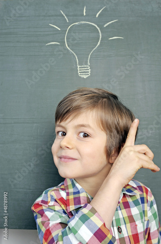 Photo: Kind mit Idee-Symbol vor Schultafel Kind mit Idee-Symbol vor Schultafel