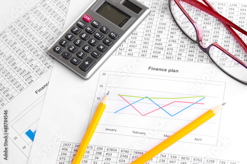 Photo: Documents, calculator and glasses close-up. Documents, calculator and glasses close-up.