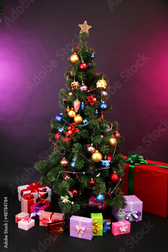Photo: Decorated Christmas tree with gifts on dark color background Decorated Christmas tree with gifts on dark color background