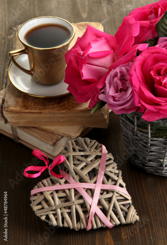 Photo: Beautiful pink roses in vase on wooden table close-up Beautiful pink roses in vase on wooden table close-up