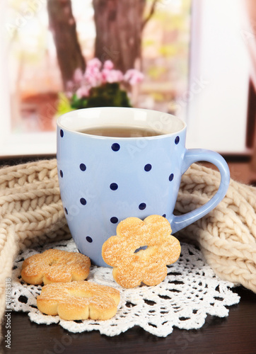 Photo: cup of tea with scarf on table in room cup of tea with scarf on table in room
