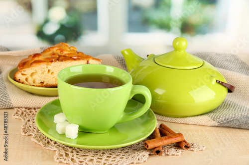 Photo: cup of tea with scarf on table in room cup of tea with scarf on table in room