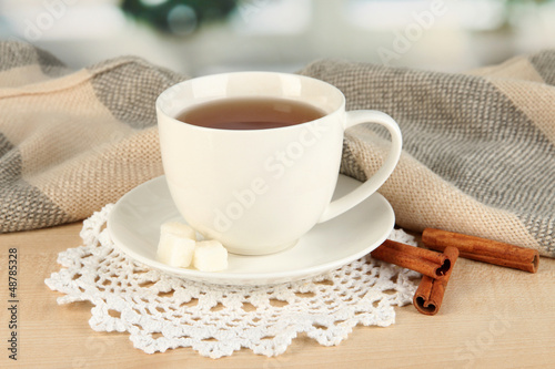 Photo: cup of tea with scarf on table in room cup of tea with scarf on table in room