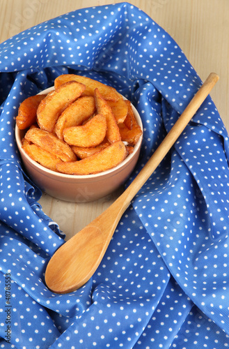 Photo: Appetizing village potatoes in bowl on blue fabric close-up Appetizing village potatoes in bowl on blue fabric close-up