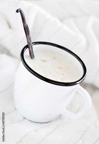 Photo: Mug of hot milk with vanilla on white knitted blanket Mug of hot milk with vanilla on white knitted blanket