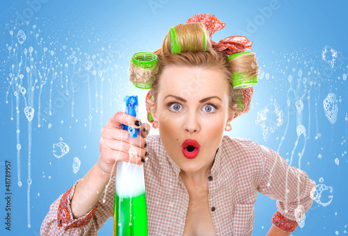 Photo: Funny housewife / woman behind window spraying Funny housewife / woman behind window spraying