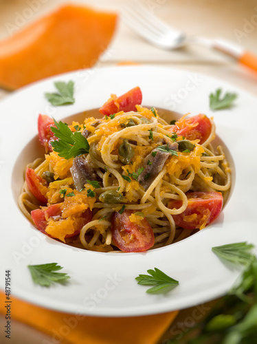 Photo: spaghetti with pumpkin anchovy caper tomatoes, selective focus spaghetti with pumpkin anchovy caper tomatoes, selective focus