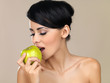 Beautiful woman eating a green apple