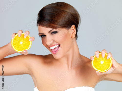 Photo: Playful woman with two orange halves Playful woman with two orange halves