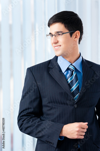 Photo: Portrait of smiling businessman at office Portrait of smiling businessman at office