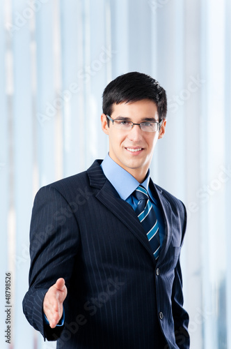 Photo: Young businessman giving hand for handshake Young businessman giving hand for handshake