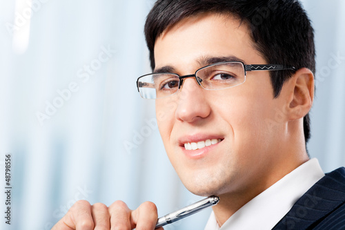 Photo: Portrait of smiling businessman at office Portrait of smiling businessman at office