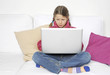 Kind arbeitet konzentriert an Laptop