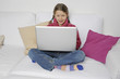 Mädchen mit Laptop auf Couch