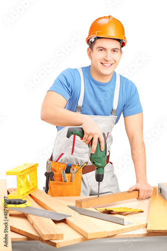 Photo: Male worker with a hand drilling machine in a workshop Male worker with a hand drilling machine in a workshop