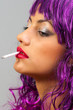 Profile of the beautiful girl with cheap purple wig smoking