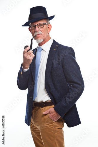 Photo: Well dressed senior man with glasses smoking pipe. Isolated. Well dressed senior man with glasses smoking pipe. Isolated.