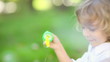 Vidéo : Happy child blowing soap bubbles in spring park. Slow motion Happy child blowing soap bubbles in spring park. Slow motion