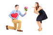 Photo: Male on knee giving a heart and flowers to a woman blowing him a Male on knee giving a heart and flowers to a woman blowing him a