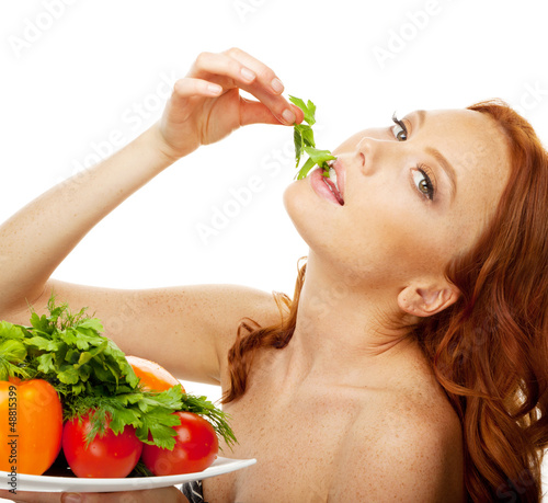 Photo: Model eating green salad from dish Model eating green salad from dish