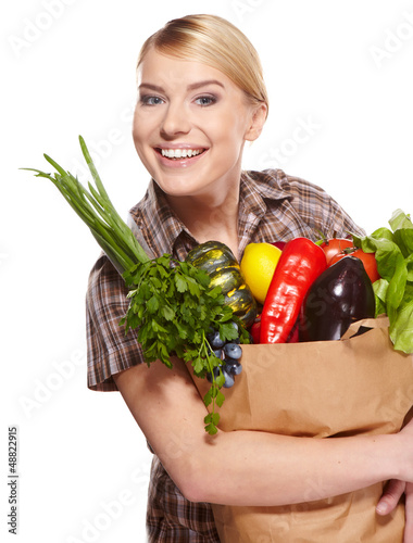 Photo: woman holding a bag full of healthy food. shopping . woman holding a bag full of healthy food. shopping .