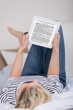 frau liest ein ebook im bett