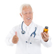 Asian senior medical doctor holding a bottle of pills