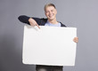 Joyful man pointing finger at white blank panel.